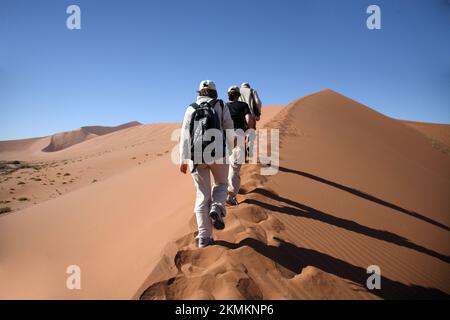 NAMIBIA. Namib-Naukluft National Park, escursionisti sulla duna di sabbia rossa Big Daddy di Sossusvlei Foto Stock