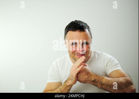 Insoddisfazione esprimere emozioni negative l'uomo adulto è arrabbiato e colpisce la sua mano con il pugno, le sue mani pelose forti ha capelli neri e l'uomo grigio tiene indietro un sorriso, a volte si arrabbia Foto Stock