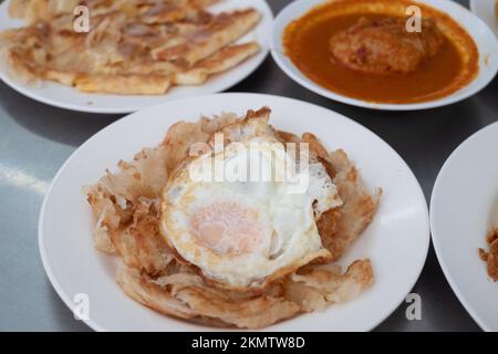 Uovo fritto con Roti e pollo al curry, cibo o ricetta thailandese speziato non vegetariano Foto Stock