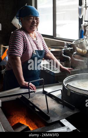 Gli spaghetti vengono cucinati in bollitori a fuoco lento su un fuoco di legno nel modo tradizionale a Yamauchi Udon, Shikoku. Foto Stock