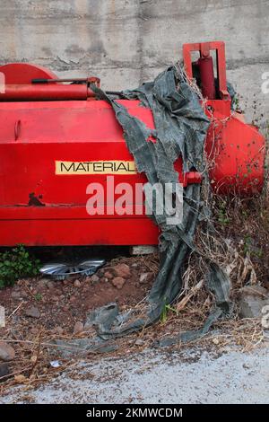 Uno scatto verticale di utensili da costruzione rossi abbandonati in una cava Foto Stock