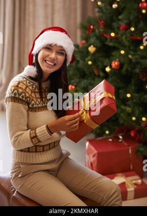 Per me. Ritratto di una giovane donna attraente che riceve un regalo la mattina di Natale. Foto Stock