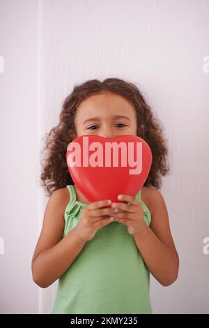 Se vi do il mio cuore per favore non romperlo. una giovane ragazza sorridente mentre tiene un giocattolo a forma di cuore. Foto Stock