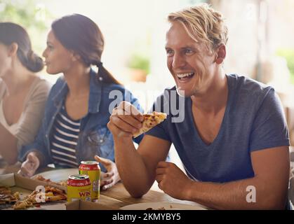 Afferrare una fetta di pizza con i buoni amici. un gruppo di amici che gustano la pizza insieme. Foto Stock