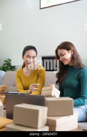 Due donne busines startup per l'introduzione sul mercato in linea, Entrepreneur packing scatole pacchi per la spedizione, venditori SME, e freelance concetto di vendita online Foto Stock