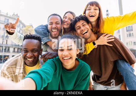 Giovane gruppo di amici multirazziali felici che scattano un ritratto selfie in città Foto Stock