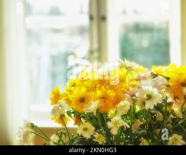 Lasciate che i fiori illuminino la vostra casa. Una bella composizione floreale in piedi di fronte ad una finestra. Foto Stock