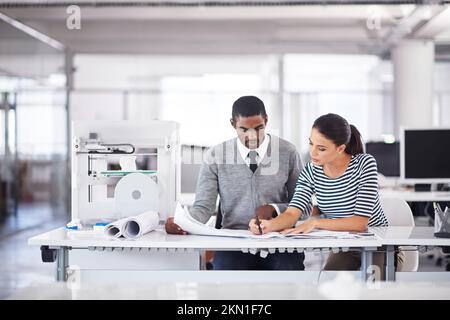 Scegliere il nuovo design perfetto. due colleghi che parlano insieme su un computer touchscreen mentre lavorano con una stampante 3d. Foto Stock