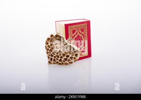 Forma del cuore e sacro libro islamico Quran mini dimensione Foto Stock