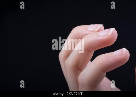 Tre dita di una mano del bambino in parte visibile in sfondo nero Foto Stock