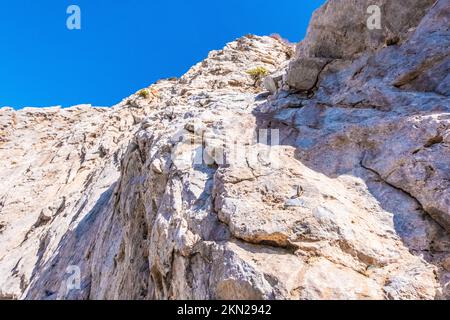 Vista ad angolo basso di una formazione in pietra di sabbia sulla riva di Santorini Foto Stock