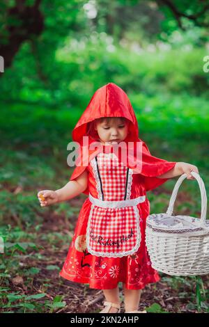 Bambino affascinante in un costume da equitazione rosso Foto Stock