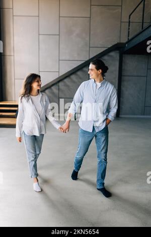 giovane coppia felice bell'uomo e donna in piedi nei loro nuovi appartamenti accoglienti Foto Stock