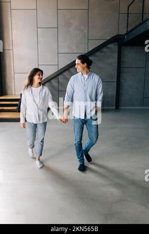 giovane coppia felice uomo e donna in piedi nei loro nuovi appartamenti accoglienti dopo un bene immobile di successo Foto Stock