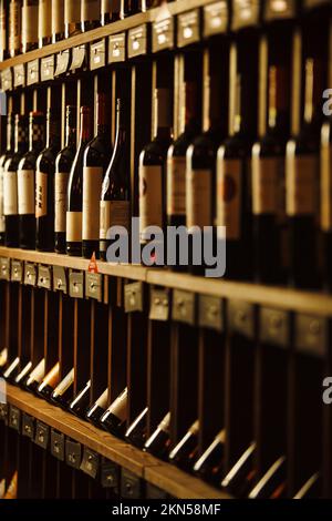 Cantina con bevande d'élite sugli scaffali con nomi scritti Foto Stock