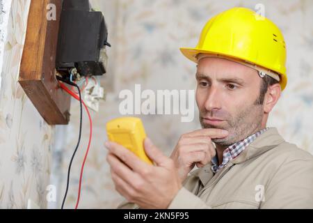 tecnico elettricista al lavoro su un quadro elettrico residenziale Foto Stock