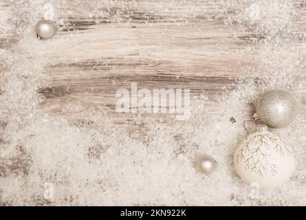 Natale sfondo grigio legno con neve artificiale e decorazioni natalizie in argento Foto Stock