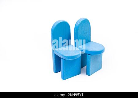 una sedia di legno blu giocattolo, un divano, due sedie con un tavolo, un tavolo giallo, sedie di legno blu imbottite. lampada gialla su sfondo bianco isolato da Foto Stock