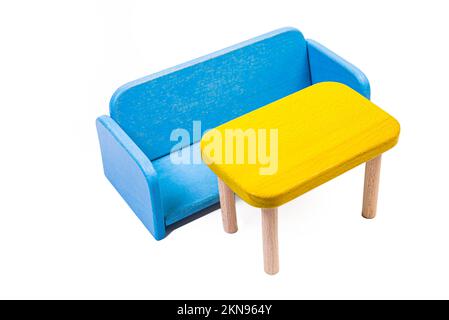 una sedia di legno blu giocattolo, un divano, due sedie con un tavolo, un tavolo giallo, sedie di legno blu imbottite. lampada gialla su sfondo bianco isolato da Foto Stock