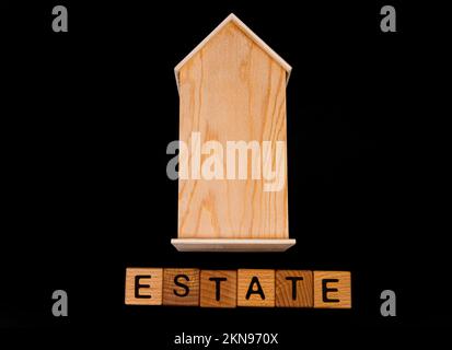 casa di legno mockup con chiavi casa, cubi di legno con parole vendita affitto, acquistare e prestito. Progetto per designer su sfondo nero Foto Stock