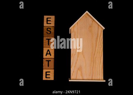 casa di legno mockup con chiavi casa, cubi di legno con parole vendita affitto, acquistare e prestito. Progetto per designer su sfondo nero Foto Stock