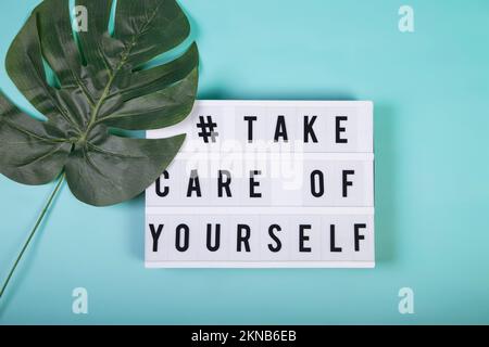 Una vista dall'alto di un lightbox con parole motivazionali per la cura di sé, la salute mentale, il benessere emotivo Foto Stock