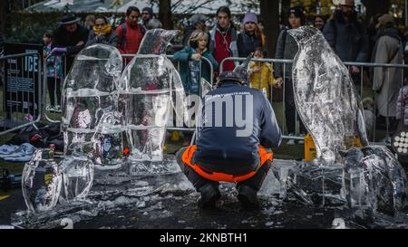 Uno scultore scolpisce i pinguini nel Canary Wharf di Londra. Foto Stock