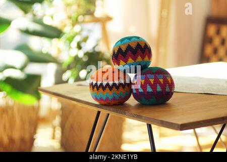 Tre palline da giocoliere colorate su un tavolo di legno in un moderno soggiorno Foto Stock