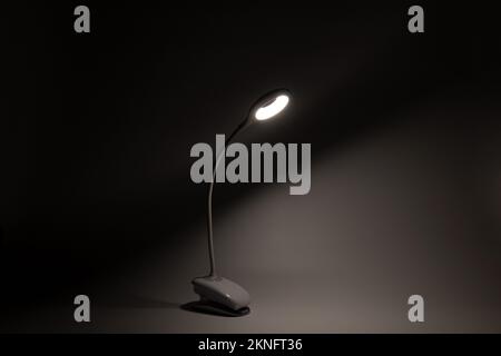 La lampada LED flessibile da tavolo sulla batteria illumina la luce al buio, la luce e la tecnologia, la lampadina Foto Stock