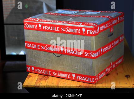 Pacco contrassegnato fragile, scatole di cartone con simbolo fragile sul tavolo di legno. Foto Stock