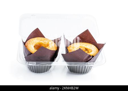 Muffin appena sfornati con confettura di albicocche ripieno in confezione di plastica isolato su bianco Foto Stock