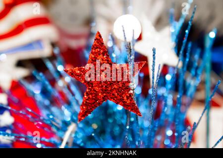 Festivo sfondo di festa con bandiera sfocata in background e glitter elementi a stella e bokeh decorativi in primo piano - rosso bianco e blu Foto Stock