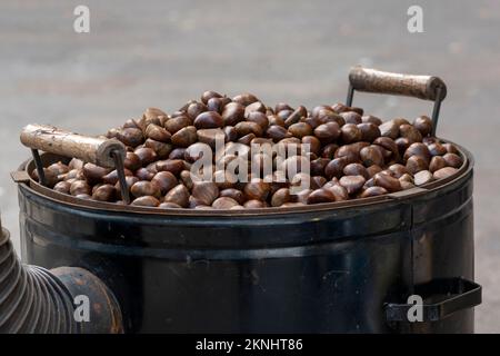 Castagne arrosto presso un venditore di strada durante l'inverno, tradizionale inverno e snack di Natale Foto Stock