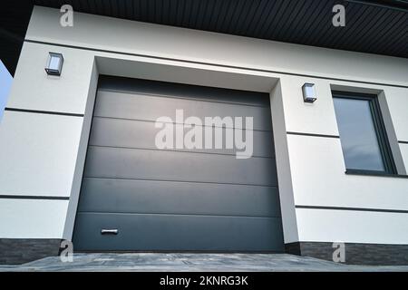 Cancello automatico del garage elettrico avvolgibile o porta a pressione in un moderno edificio privato al piano terra Foto Stock