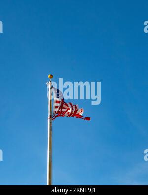 Ritorto e strappata bandiera americana su fondo blu intenso, simbolico di una nazione dilaniata concetto. Foto Stock