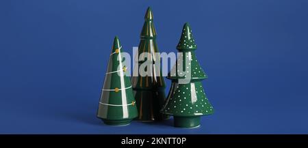 Alberi di Natale in ceramica su sfondo blu Foto Stock