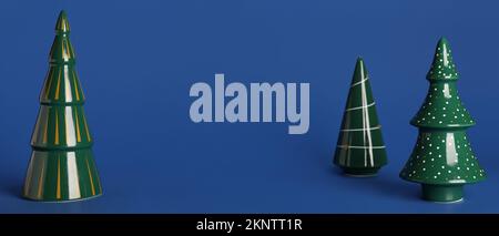 Alberi di Natale in ceramica su sfondo blu con spazio per il testo Foto Stock