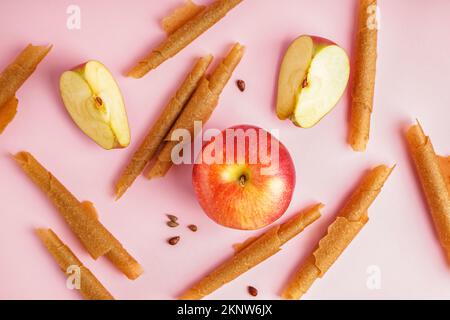 Panini di gustose pastiglie di mela su sfondo rosa Foto Stock