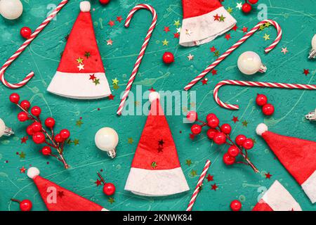 Composizione con cappelli di Santa, decorazioni e canne caramelle su sfondo colorato Foto Stock