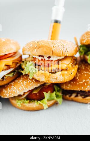 Un primo piano di diversi tipi di hamburger impilati l'uno sull'altro con sfondo sfocato Foto Stock