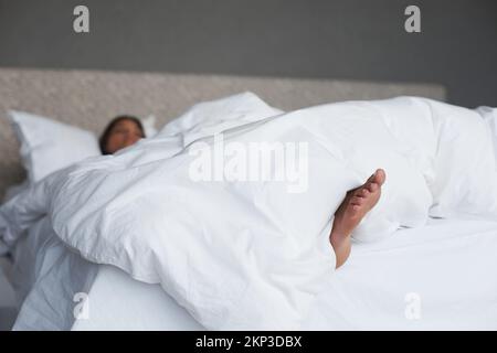 Amare questo sabato mattina si trovano dentro. una giovane donna piedi che esce dal piumino come dorme. Foto Stock