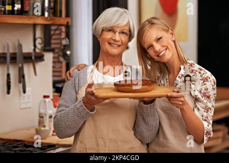 Le migliori lezioni vengono da Gran. una giovane donna e sua nonna mostrando le loro abilità di cottura. Foto Stock