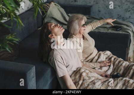 Vecchia donna che gioca a playstation divertendosi come pazzo insieme a sua figlia adulta. Concetto di intrattenimento con playstation. Il concetto di avere Foto Stock