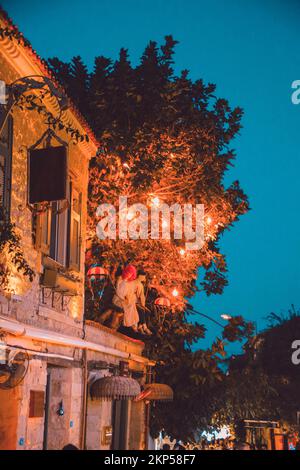 Turisti che mangiano per le strade del resort, belle lampade, decorazioni meravigliose Foto Stock