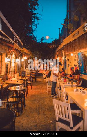 Turisti che mangiano per le strade del resort, belle lampade, decorazioni meravigliose Foto Stock