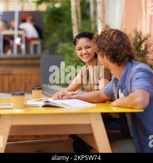 Partecipare ad alcuni studi tra classi. Uno scatto di studenti universitari che si divertono con la loro sessione di studio all'aperto. Foto Stock