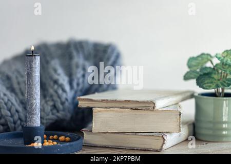 Composizione casalinga accogliente con libri in primo piano sul tavolo. Foto Stock