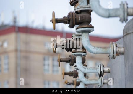 Valvola manuale per l'area industriale sullo sfondo della città. Valvola a sfera con comando manuale. Sistema di raccordo per tubi. Sfera flangiata in acciaio inox Foto Stock