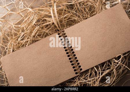 Notebook a spirale posizionato su uno sfondo di paglia Foto Stock