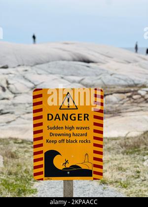 Un primo piano verticale di un cartello segnaletico per tenere fuori le rocce nere a Peggy's Cove, Canada Foto Stock